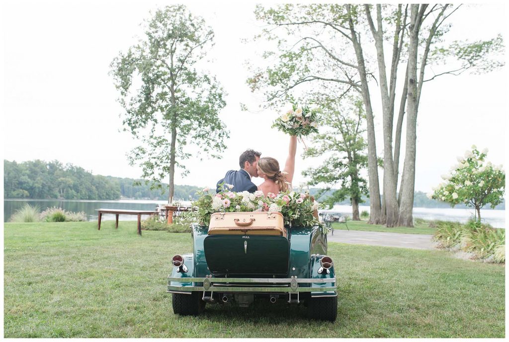 modern chic bride and groom bridal portrait send off in classic car with vintage suitcases and stunning florals at new jersey venue