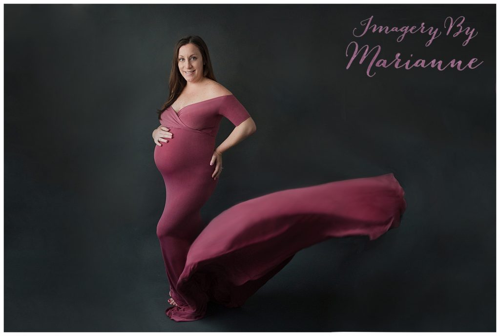 Pregnant mom holding belly in one of my studio wardrobe dresses.